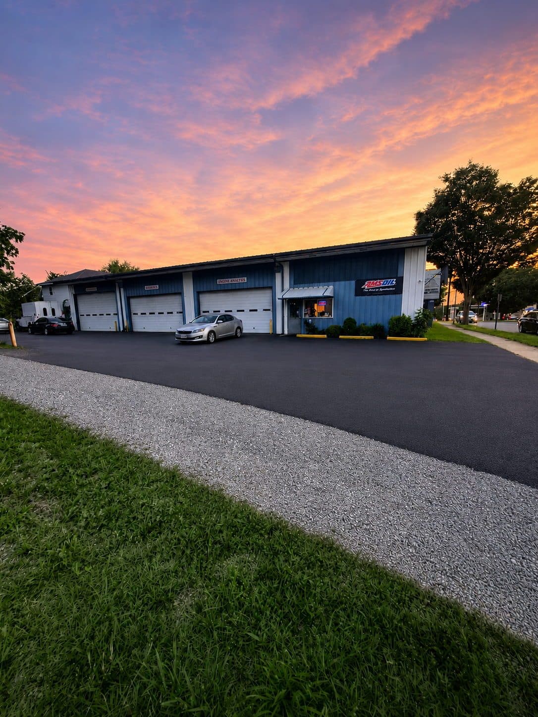 Zoom Automotive auto repair shop at 2014 12th Street in Lynchburg, Virginia at sunset, showing all three service bays, the office, and the AMSOIL sign