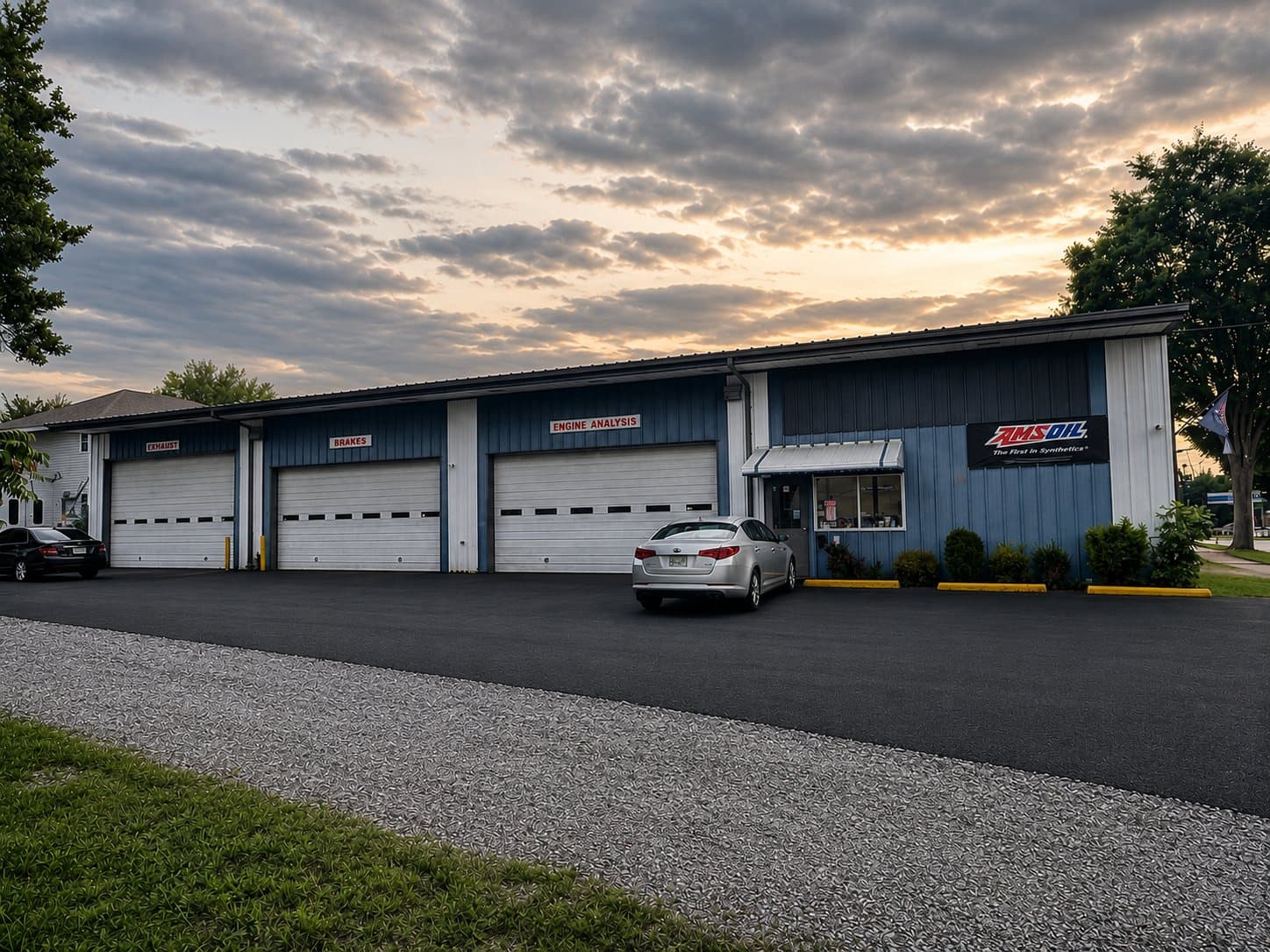 Zoom Automotive auto repair shop at 2014 12th Street in Lynchburg, Virginia at dusk, showing the exhaust, brakes and engine analysis service bays, the office, and the AMSOIL sign